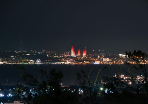 A stunning night view of Baku's illuminated skyline featuring the iconic Flame Towers.