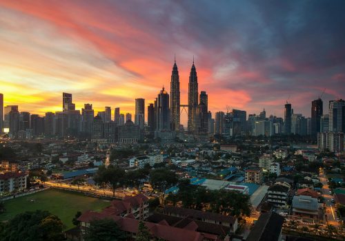 Breathtaking view of Kuala Lumpur skyline with Petronas Towers at sunset, showcasing vibrant urban architecture.